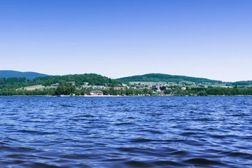 The Lipno Dam - Horni Plana (Czech Republic) in a bright summer day. The lake is calm, has clean blue water. There are no clouds in the sky.