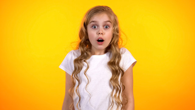 Funny schoolgirl with widely opened eyes looking to cam, shocking news, promo