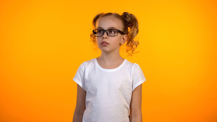 Pensive teenage schoolgirl looking aside, planning future career, little genius