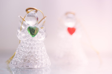Two small glass angel statuettes with hearts
