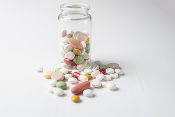 Pills and bottle on white background. Treatment and health care concept.