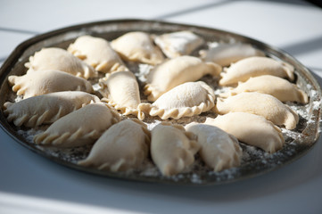 Dumplings vareniki with cottage cheese and jam on a round dish. Traditional Russian food.