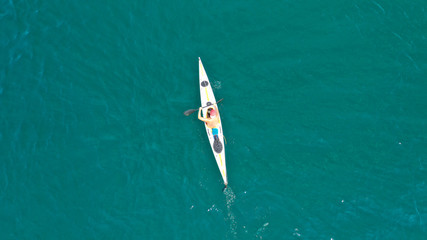 Aerial drone photo of fit man practising sport canoe in calm water sea