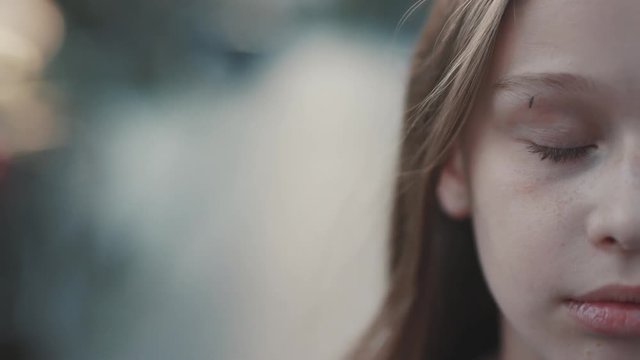 Close-up footage of nice teenager with closed eyes. Mosquito trying to bit little girl. Half of face. Natural beauty. Hands. Outside.