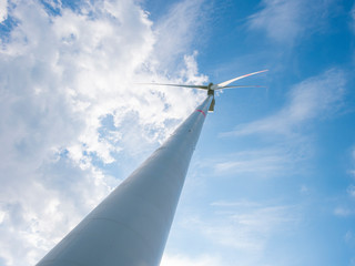 Wind turbine with blue sky and clouds