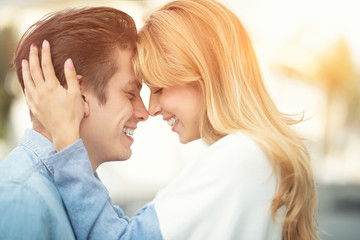 Happy to spending time together. Young beautiful couple outdoor fashion portrait. Attractive boy and girl hugging and kissing.