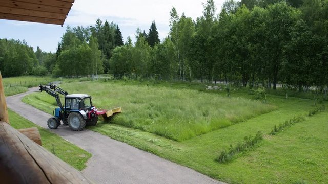Hay making on the lawn in front of the farmer's house rotary mower timelap