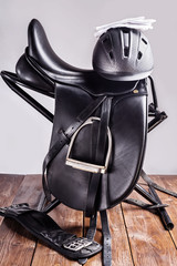Black professional  leather dressage saddle in complete with riding helmet and gloves