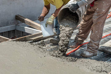 Pouring concrete at a construction site. Filling a rooftop with cement over the pipelines - obrazy, fototapety, plakaty