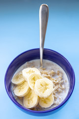 oatmeal with banana in a blue plate on a blue background