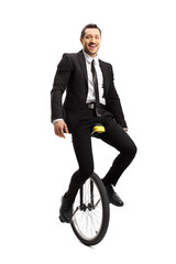 Businessman riding a unicycle and smiling at the camera © Ljupco Smokovski