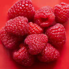 Ripe red raspberry on red background. Top view
