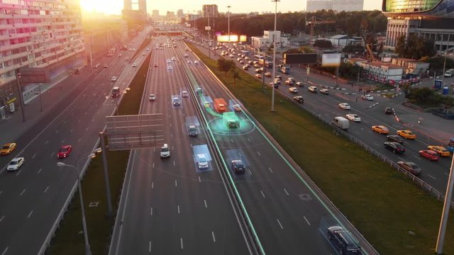 Beautiful aerial view to autonomous cars self-driving on the highway in Moscow. Picturesque aerial panorama of the road traffic in a big city on the sunset.