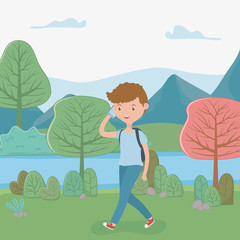 Obraz na płótnie Canvas young boy walking using smartphone in the park