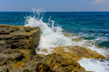  splashing waves crashing against a stone beach