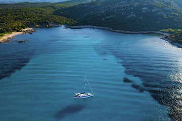 View from above, stunning aerial view of a sailing boat floating on a beautiful turquoise clear...