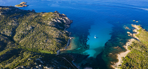 View from above, stunning aerial view of a sailing boat floating on a beautiful turquoise clear sea. Maddalena Archipelago National Park, Sardinia, Italy.