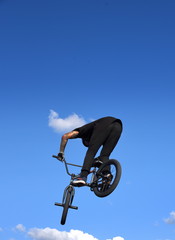 Silhouette eines waghalsigen BMX-Bikers vor strahlend blauem Himmel