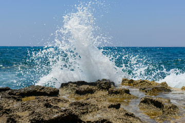  splashing waves crashing against a stone beach