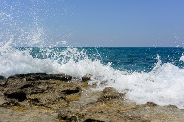  splashing waves crashing against a stone beach
