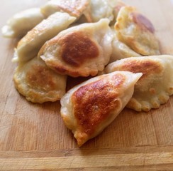 smażone pierogi na drewnianej desce