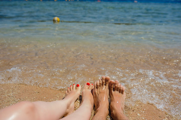 top view of man and woman legs on the beach