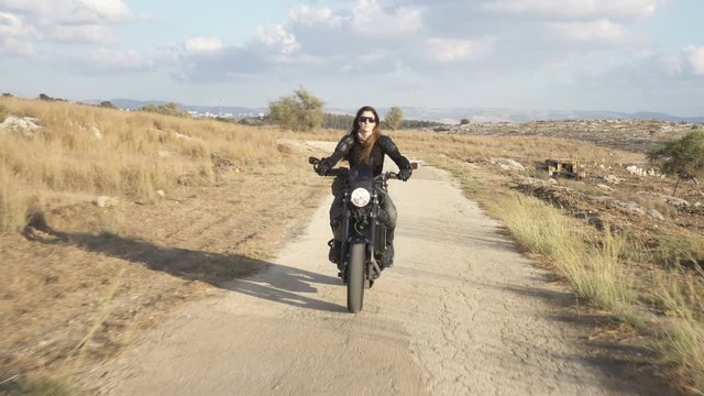 An attractive woman biker riding on her motorcycle.