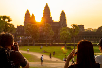 Photographer at Angkor Wat temple in Siem Reap, Cambodia. Smartphone photo and people walking....