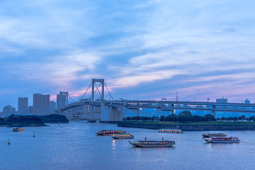お台場　ライトアップしたレインボーブリッジと屋形船が浮かぶ風景