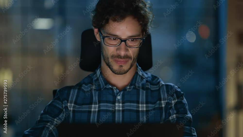 Poster portrait of the handsome and successful young creative entrepreneur working at his desk using laptop