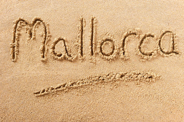 Mallorca majorca spain word written in sand on a sunny spanish summer beach holiday vacation travel destination sign writing message photo