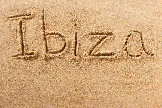 Ibiza word written in sand on a sunny spanish spain island summer beach holiday vacation travel destination sign writing message photo