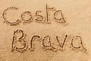 Costa brava spain word written in sand on a sunny spanish summer beach holiday vacation travel destination sign writing message photo