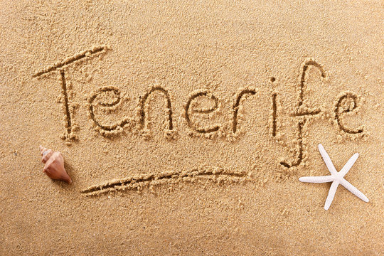 Tenerife canary islands word written in sand on a sunny spanish summer beach with starfish holiday vacation travel destination sign writing message photo