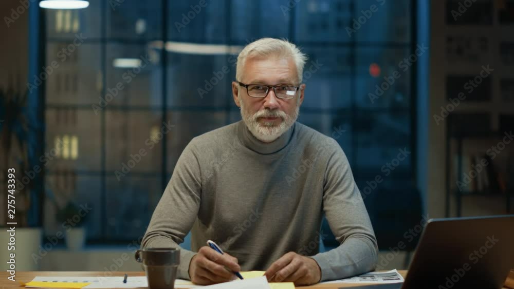 Poster portrait of the handsome and successful middle aged bearded businessman working at his desk using la