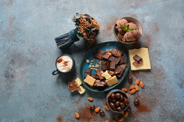 Obraz na płótnie Canvas Cup of coffee, black and white chocolate, almond nuts. Coffee break concept