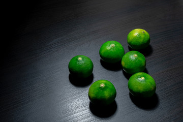 Fresh limes on wooden table background. Selective focus.