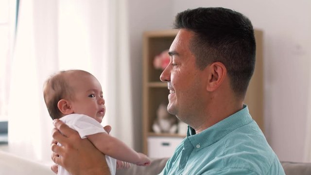 family, parenthood and fatherhood concept - middle aged father comforting little baby daughter at home