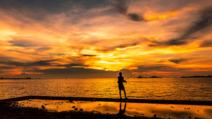 twilight seascape the sunset and light gold with fisherman silhouette foreground on island in Thailand