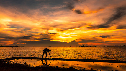 twilight seascape the sunset and light gold with fisherman silhouette foreground on island in Thailand