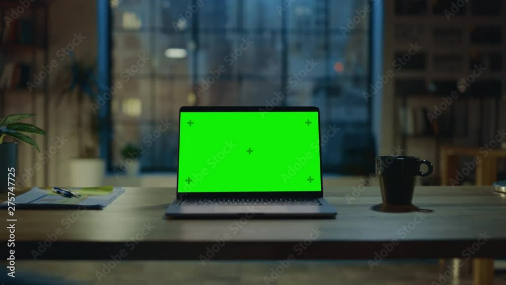 Poster mock-up green screen laptop standing on the desk in the modern creative office. in the background wa