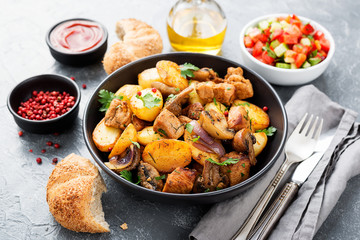 Baked potatoes with meat and mushrooms served with fresh salad and bread bun.