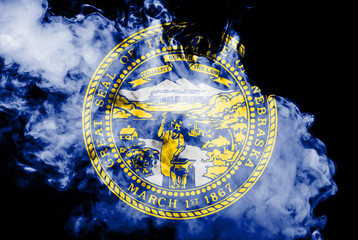 The national flag of the US state Nebraska in against a gray smoke on the day of independence in...