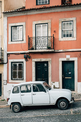 Fototapeta na wymiar An old car on a cobblestone street in Lisbon, Portugal