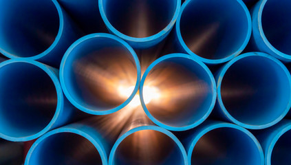 Group of blue water pipes That is stacked into a graphic format With light coming from behind - obrazy, fototapety, plakaty