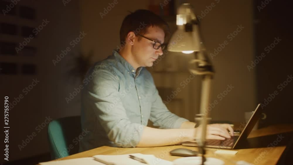 Poster professional man sitting at his desk in office studio working on a laptop in the evening. man analyz