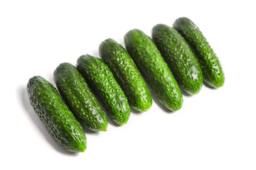 Row of fresh green gherkins isolated on white background