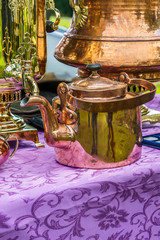 Fototapeta na wymiar copper samovars, kettle and other old dishes on a street sale
