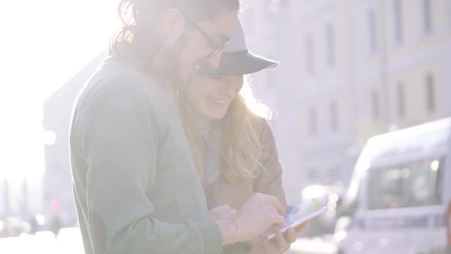 happy couple tourist susing smartphone for navigation with soft natural morning lighting. Mixed race couple. Sunrise. Close up
