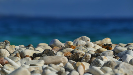 Fototapeta na wymiar Pebbles stone beach with blurred sea background, wallpaper